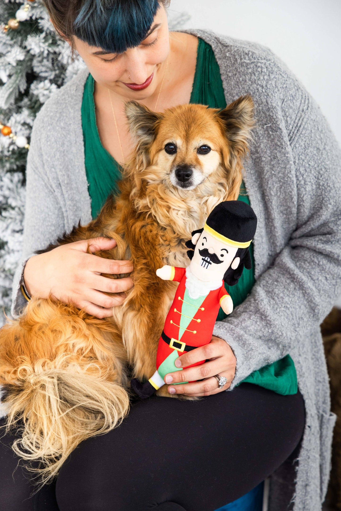 women posed with tan and white dog and "muttcracker "toy