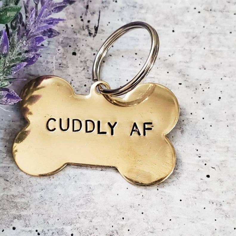 dog bone shaped dog tag with text "CUDDLY AF" 