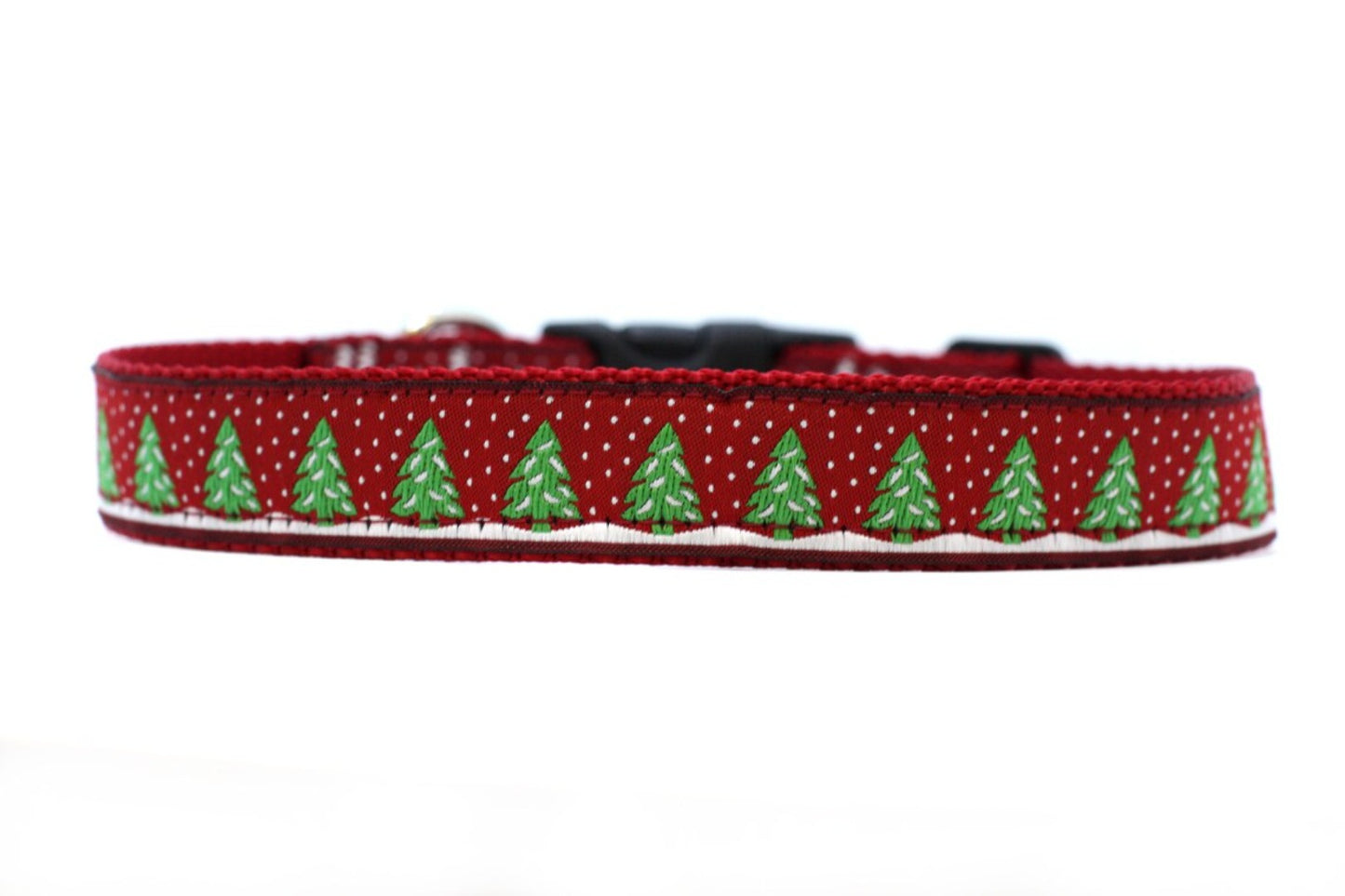 close up of collar. red background with snow covered green trees surrounded by snow