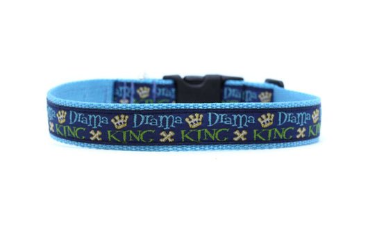 close up of collar. navy background with gold crowns and "drama king" in light blue and green